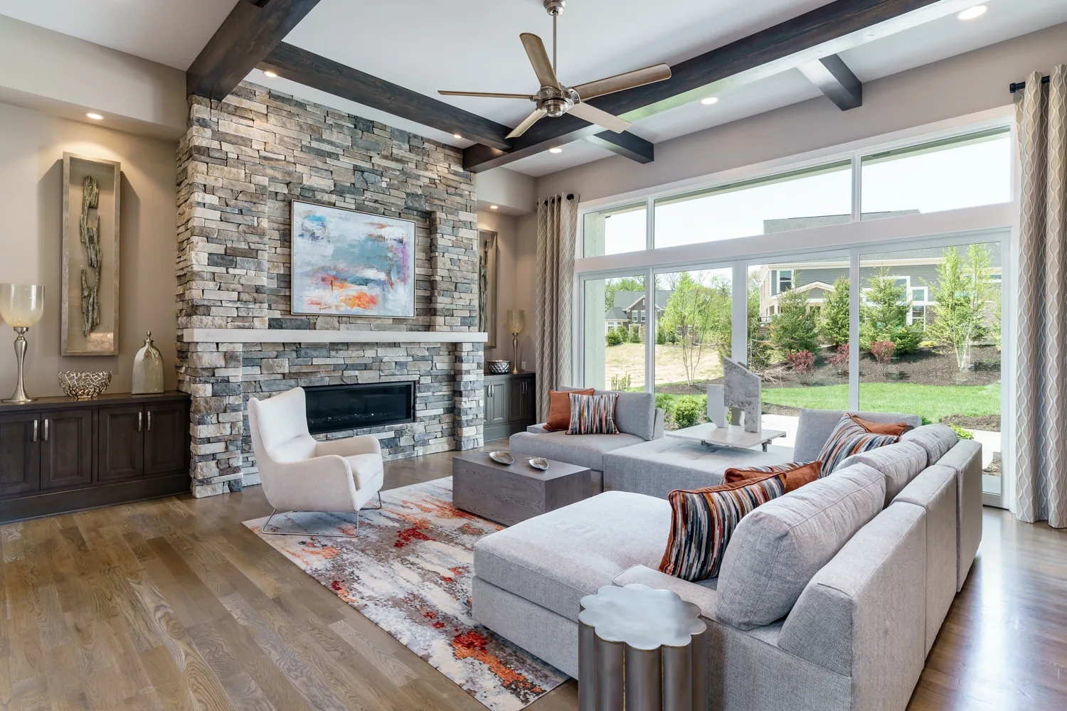Bright living room with stone fireplace, exposed beams and garden views