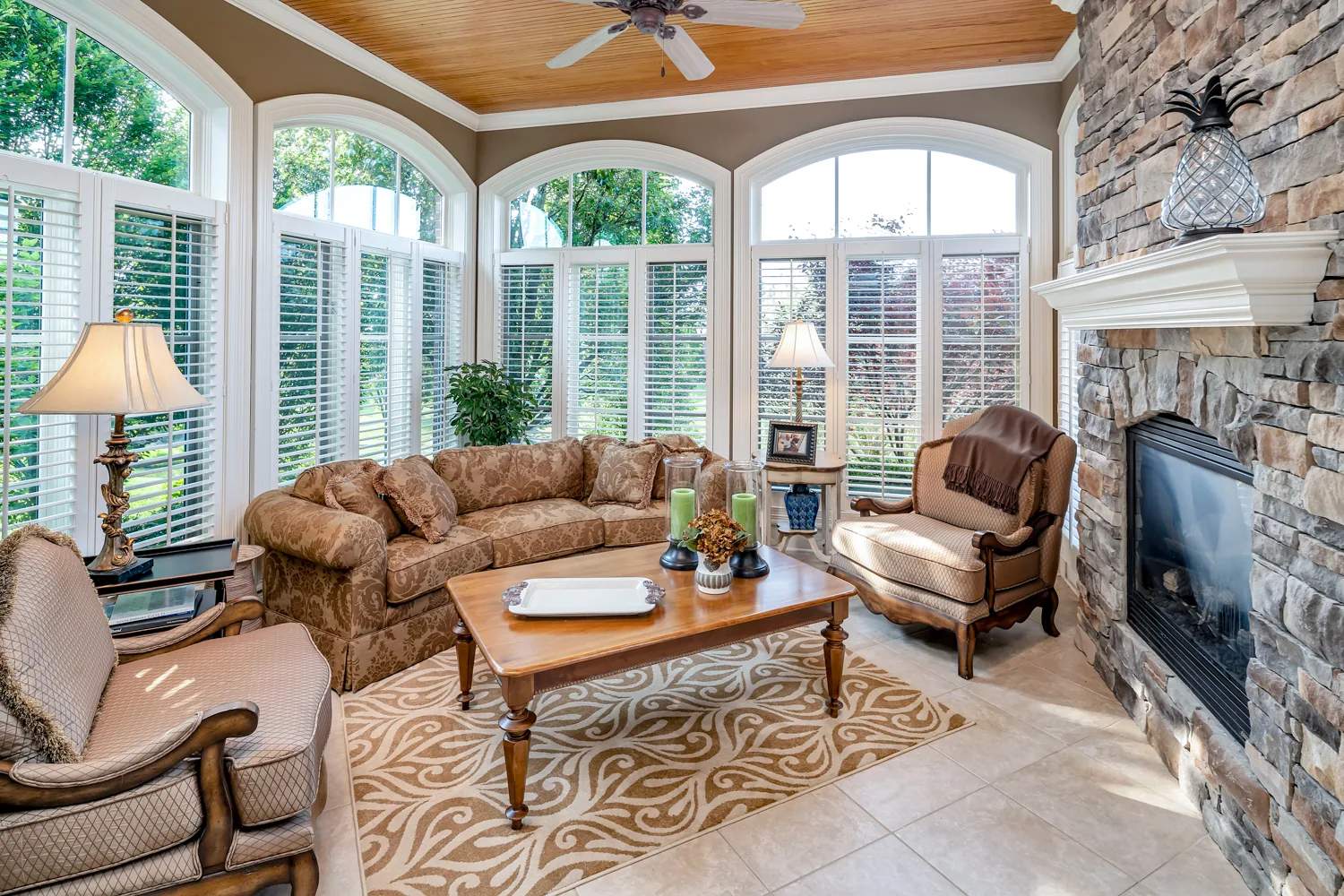 Sunroom with large windows overlooking a leafy garden